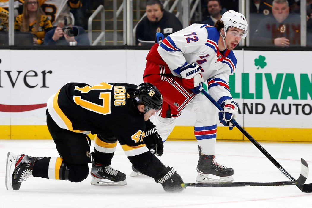 Český útočník Filip Chytil z New York Rangers uspěl v souboji o puk s obráncem Bostonu Torey Krugem