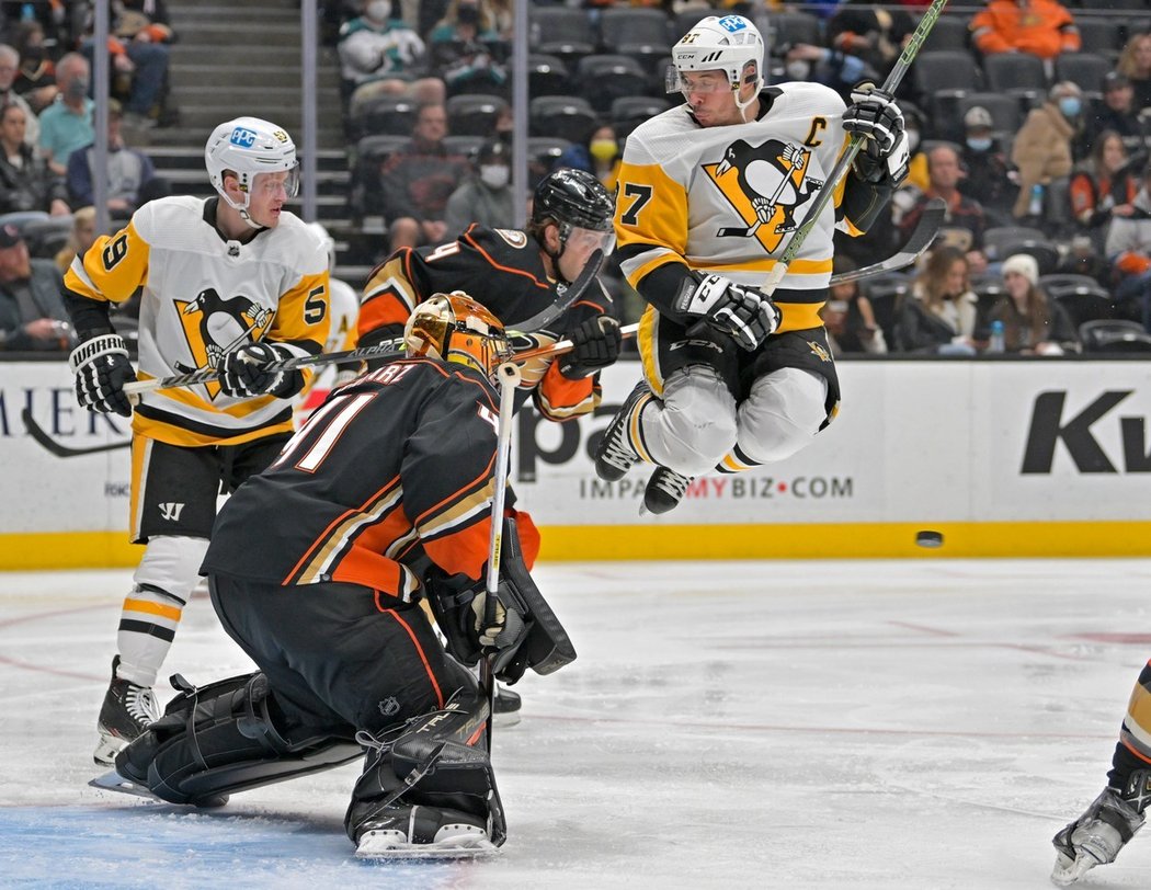 Kapitán Penguins Sidney Crosby nadskakuje před brankářem Ducks Anthonym Stolarzem, na kterého letí dělová rána od Jevgenije Malkina