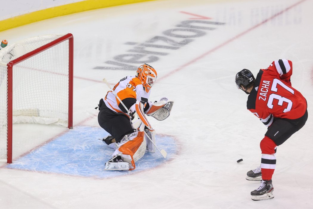 Útočník Devils Pavel Zacha tváří v tvář brankáři Flyers Brianu Elliottovi