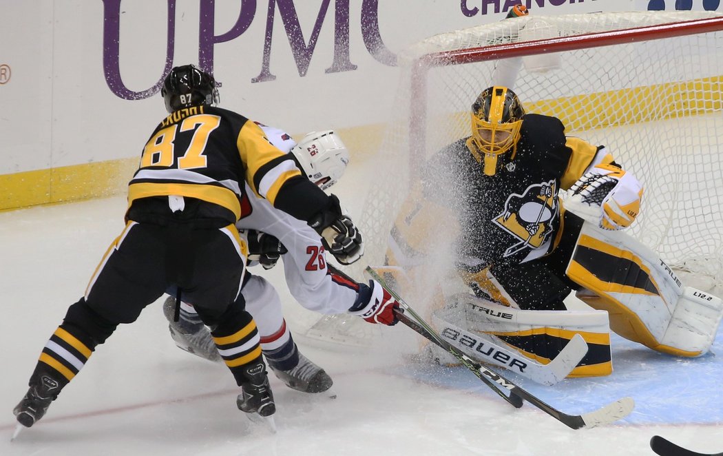 Kapitán Pittsburghu Sidney Crosby čistí prostor kolem brány Caseyho DeSmitha