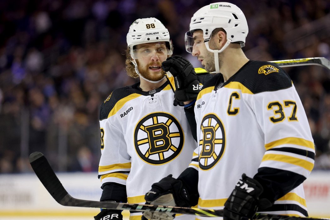 Český snajpr David Pastrňák se baví s kapitánem Bruins Patricem Bergeronem