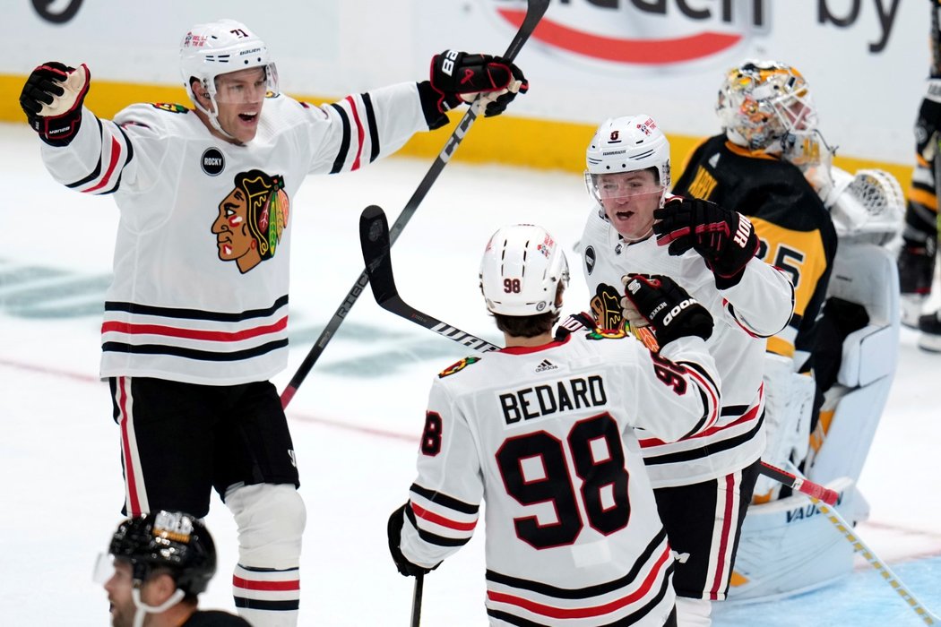 Hokejisté Chicaga se radují z gólu Ryana Donata (vpravo), na kterém se prvním bodem v NHL podílel i Connor Bedard