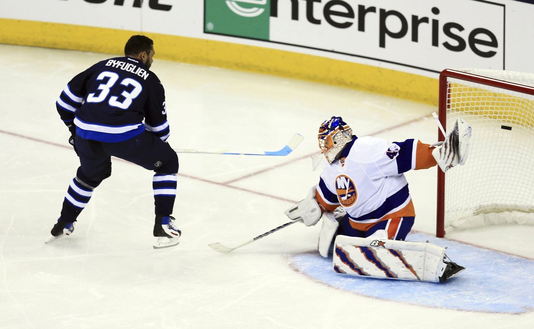 Dustin Byfuglien v souboji se slovenským brankářem Halákem.