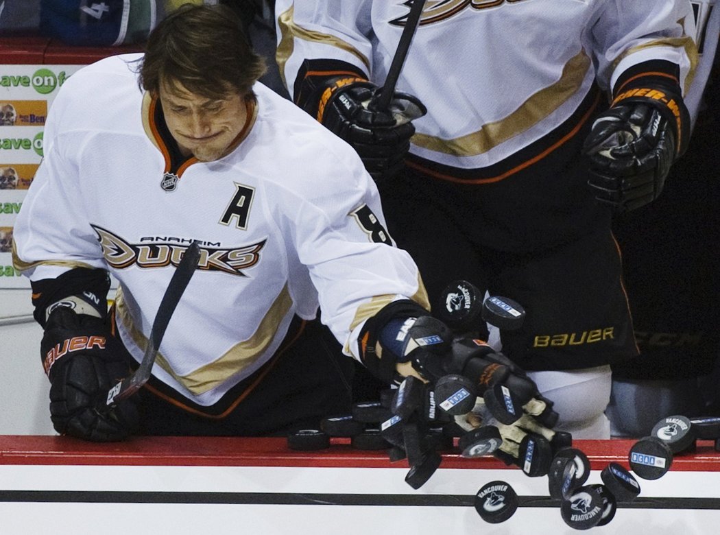 Teemu Selänne hází na led puky při rozbruslení.