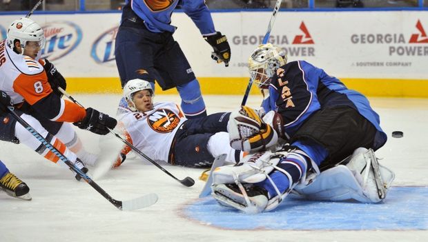 Český brankář Ondřej Pavelec v dresu Atlanty chytá svým zákrokem jednu ze šancí hokejistů Islanders. Český brankář Ondřej Pavelec v dresu Atlanty chytá svým zákrokem jednu ze šancí hokejistů Islanders.