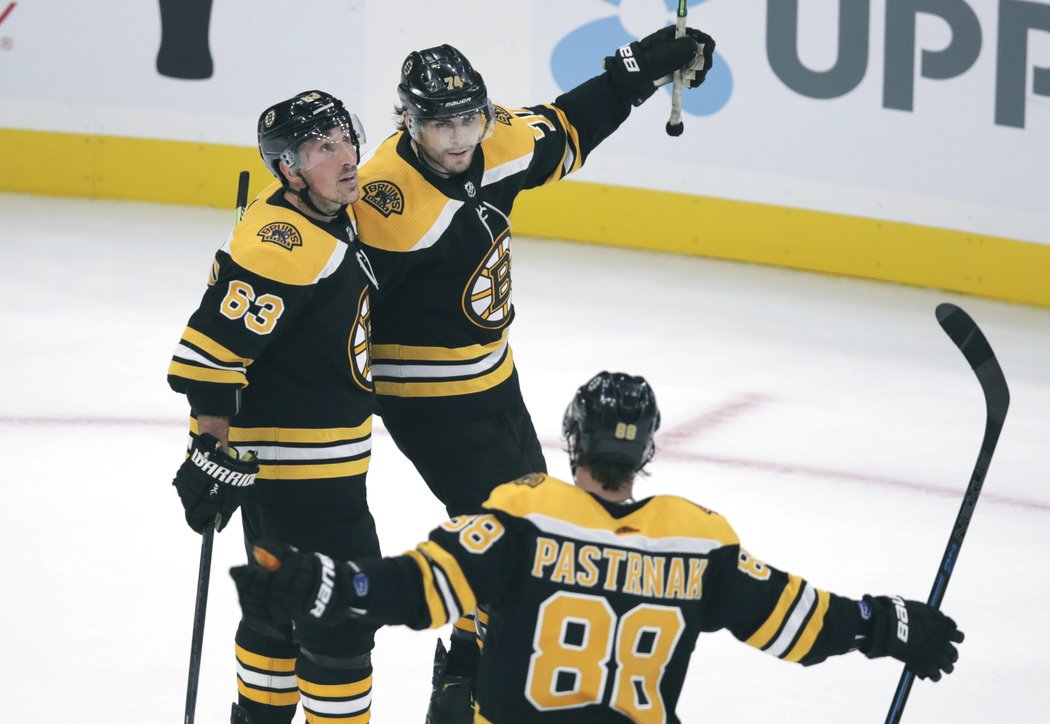 Brad Marchand, Jake DeBrusk a David Pastrňák slaví gól v prodloužení