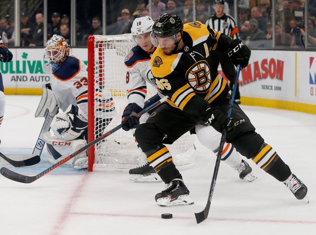 David Krejčí si kryje kotouč před edmontonským Jujharem Khairou, vše z branky sleduje Cam Talbot