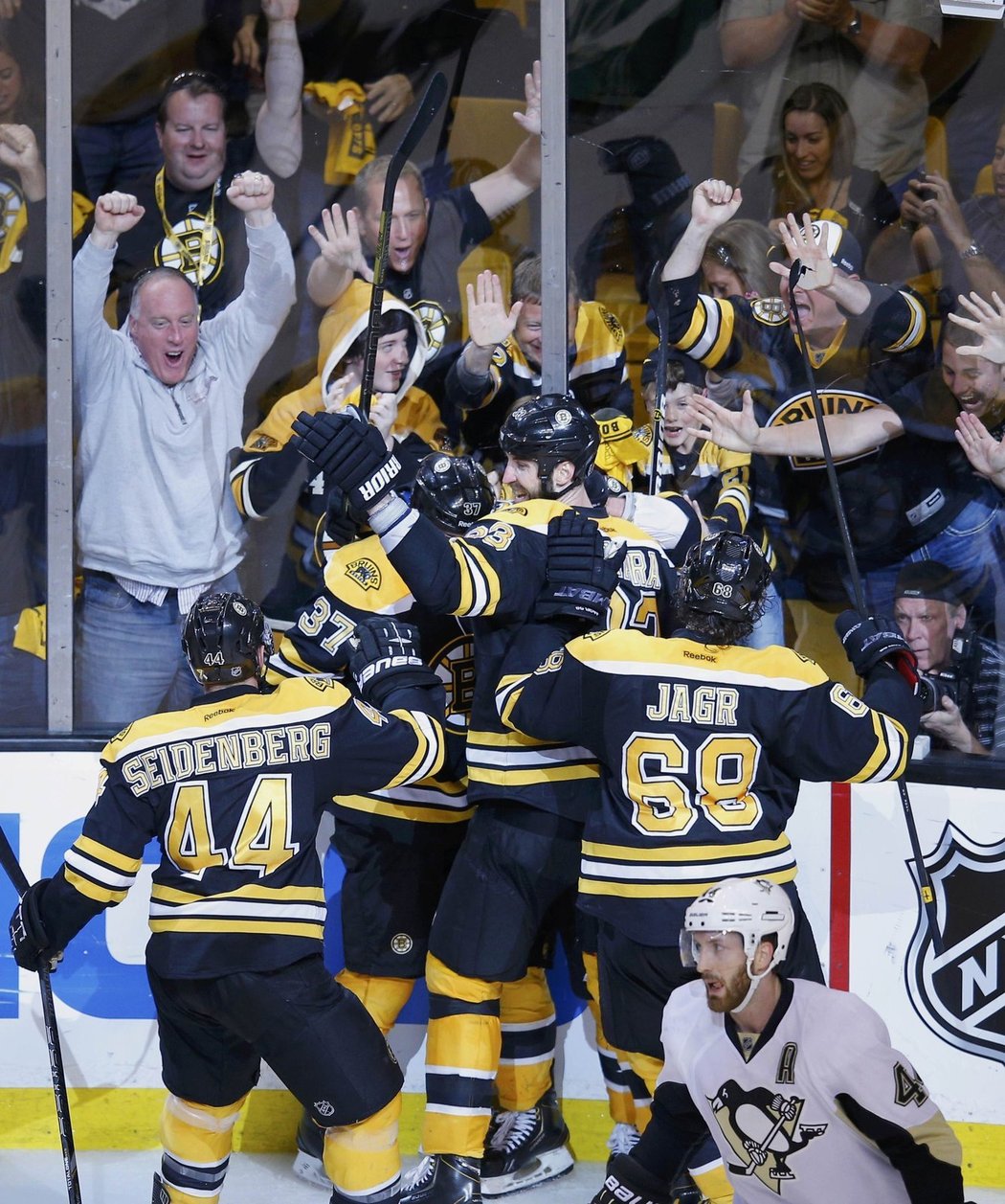 Hráči Bruins skáčou na střelce Bergerona.