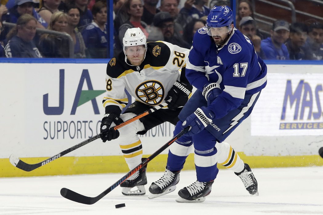 Alex Killorn ujíždí s kotoučem, hlídá ho Ondřej Kaše z Bostonu