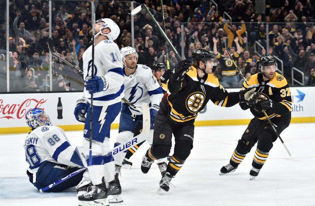 Jake DeBrusk a asistent kapitána Patrice Bergeron se radují z trefy Davida Pastrňáka.