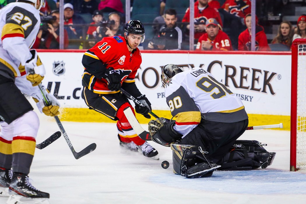 Robin Lehner z Vegas právě zastavil střelecký pokus Mikaela Backlunda z Calgary