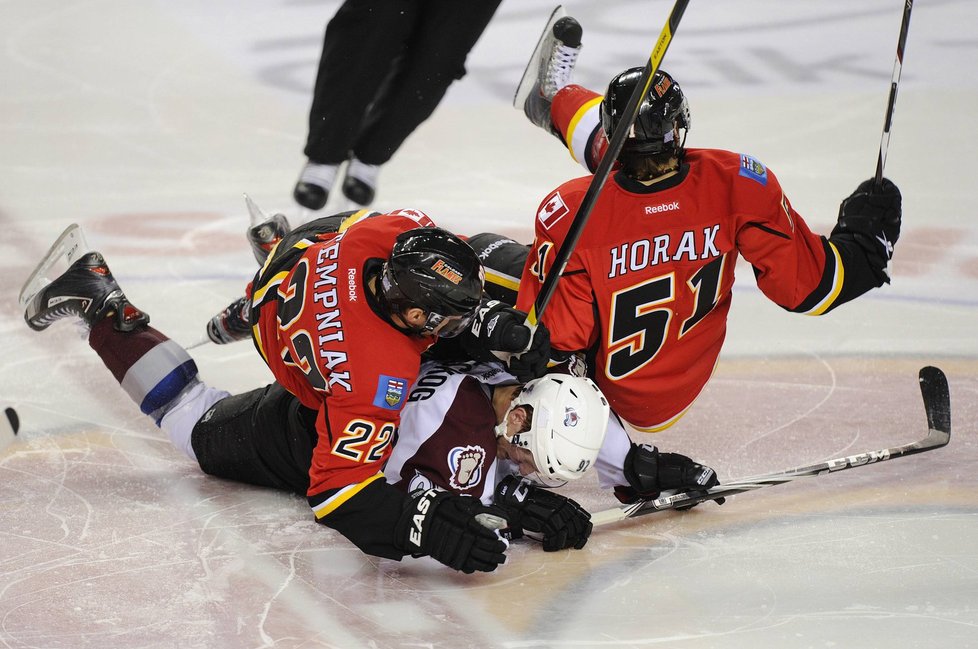 Spoluhráči z Calgary Lee Stempniak a Roman Horák (vpravo) padají na coloradského Gabriela Landeskoga