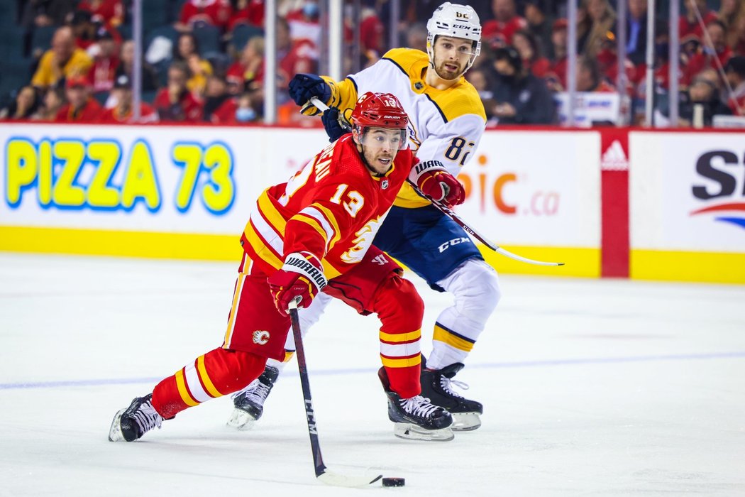 Johnny Gaudreau si kryje puk před Thomasem Novakem z Nashvillu