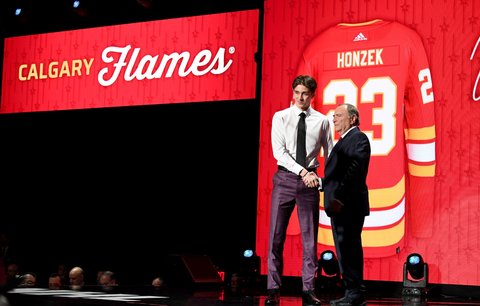 Slovenský útočník Samuel Honzek se přidává na draftu ke Calgary a přijímá gratulaci od šéfa NHL Garyho Bettmana