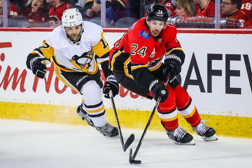 Bryan Rust napadá obránce Travise Hamonica z Calgary