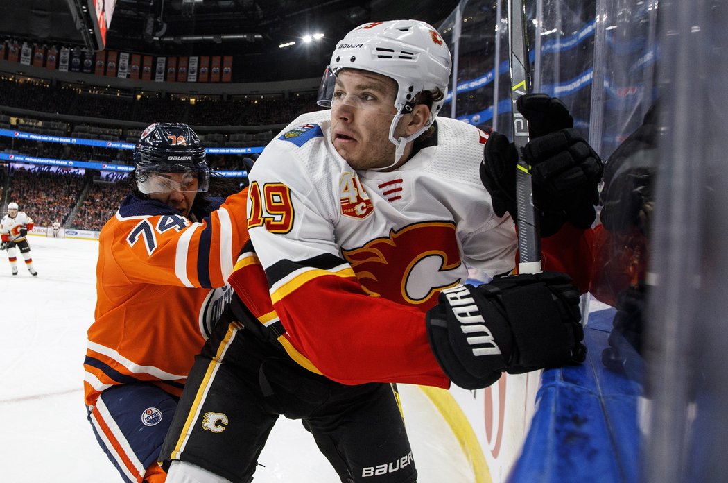 Matthew Tkachuk přimáčknutý na mantinel obráncem Ethanem Bearem z Edmontonu