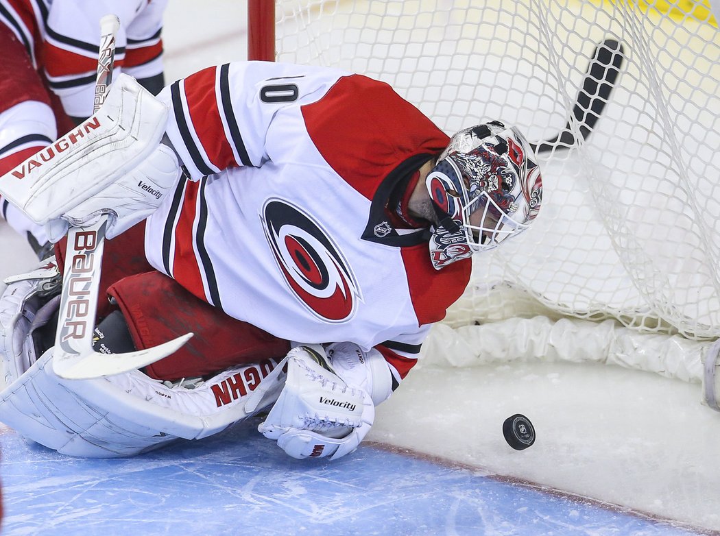 Brankář Cam Ward sleduje jeden z pěti puků, které v Calgary skončily za jeho zády. Hurricanes prohráli na kanadském ledě 0:5 a s pouhými dvěma body za prohry v prodloužení se dělí s Buffalem o poslední místo v NHL.