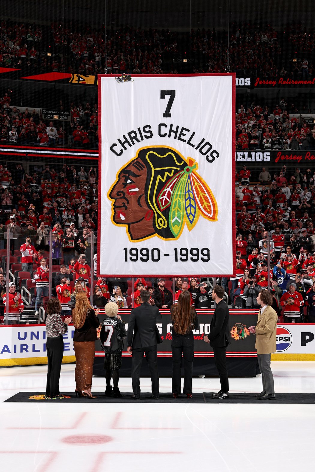 Dres a číslo Chrise Cheliose již stoupá ke stropu haly v Chicagu