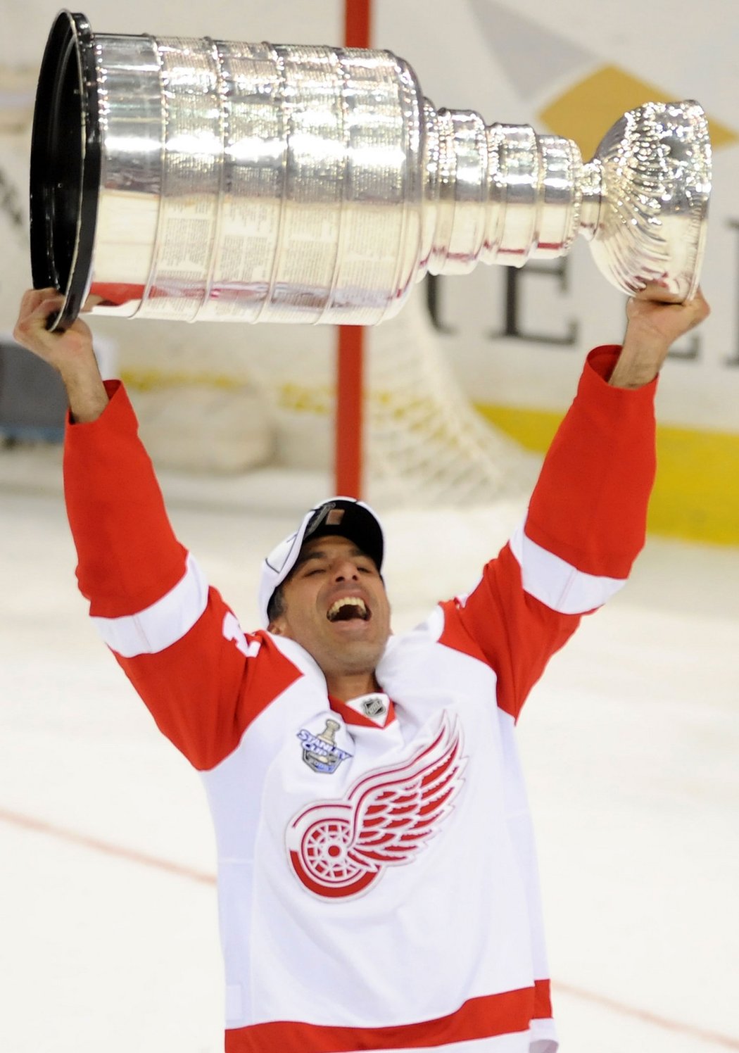 Chris Chelios v dresu Detroitu zvedá nad hlavu Stanley Cup