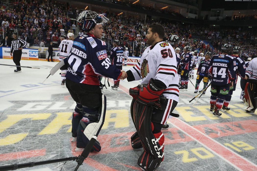 Corey Crawford se zdraví s brankářem Eisbären Franzgrebem