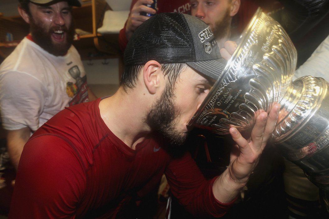 Jak chutná šampaňské ze Stanley Cupu zkouší Jonathan Toews.