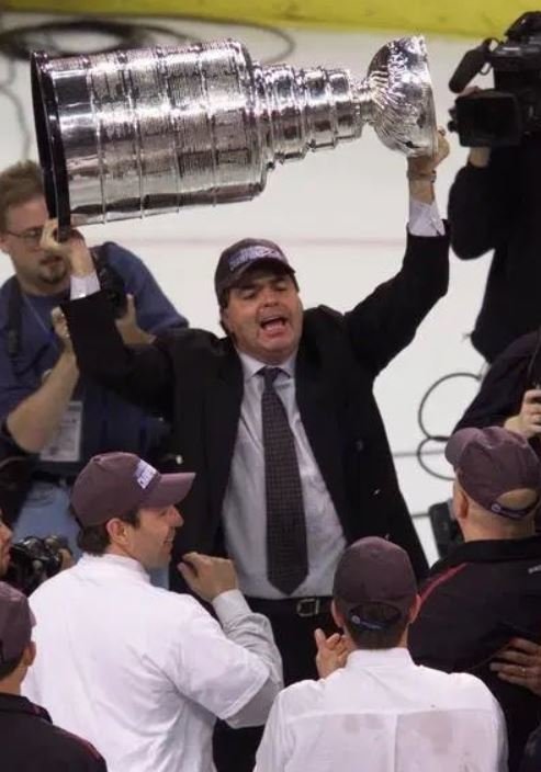 Generální manažer Colorada Pierre Lacroix zvedá nad hlavu Stanley Cup
