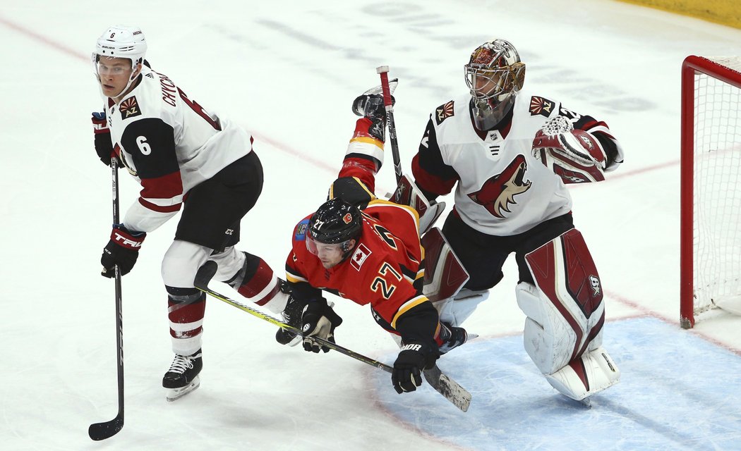 Austin Czarnik z Calgary padá v brankovišti Arizony