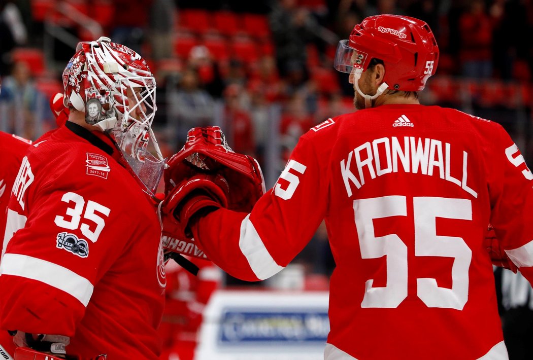 Brankář Red Wings Jimmy Howard se raduje s obráncem Niklasem Kronwallem z výhry nad Flames