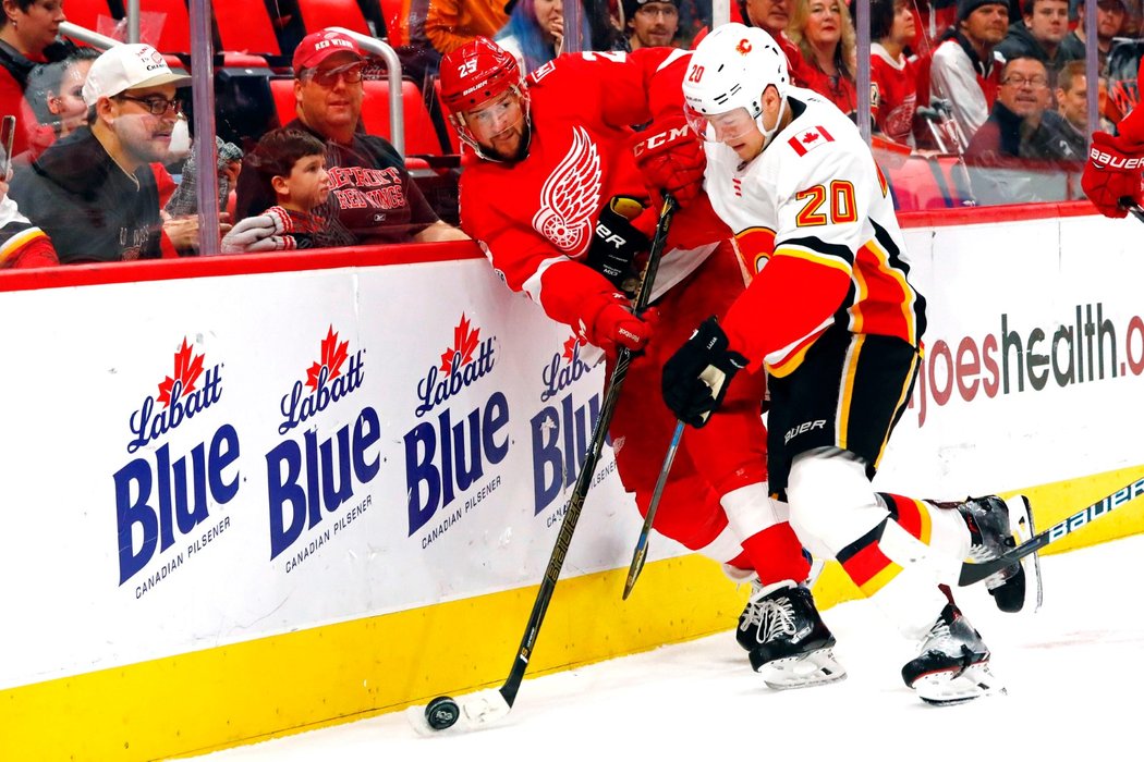 Obránce Detroitu Mike Green v souboji s Curtisem Lazarem z Calgary