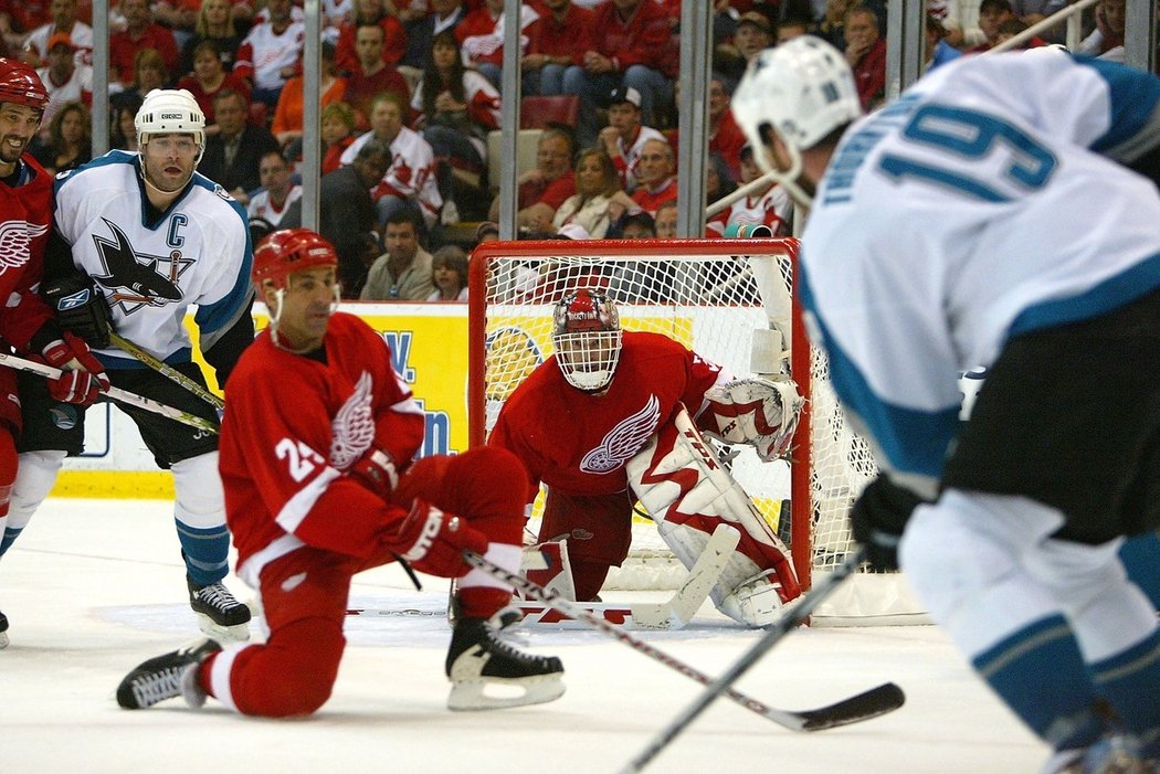 Dominik Hašek v zápase proti San Jose, vlevo Patrick Marleau, vpravo Joe Thornton