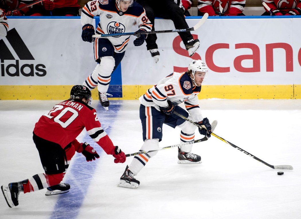 Connor McDavid ujíždí s pukem soupeři z New Jersey