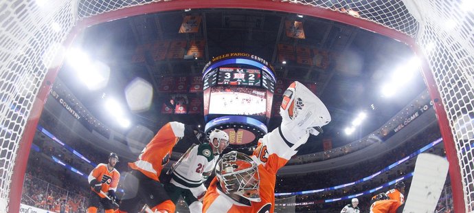 Michal Neuvirth v brance Philadelphie skáče po střele Charlieho Coylea z Minnesoty