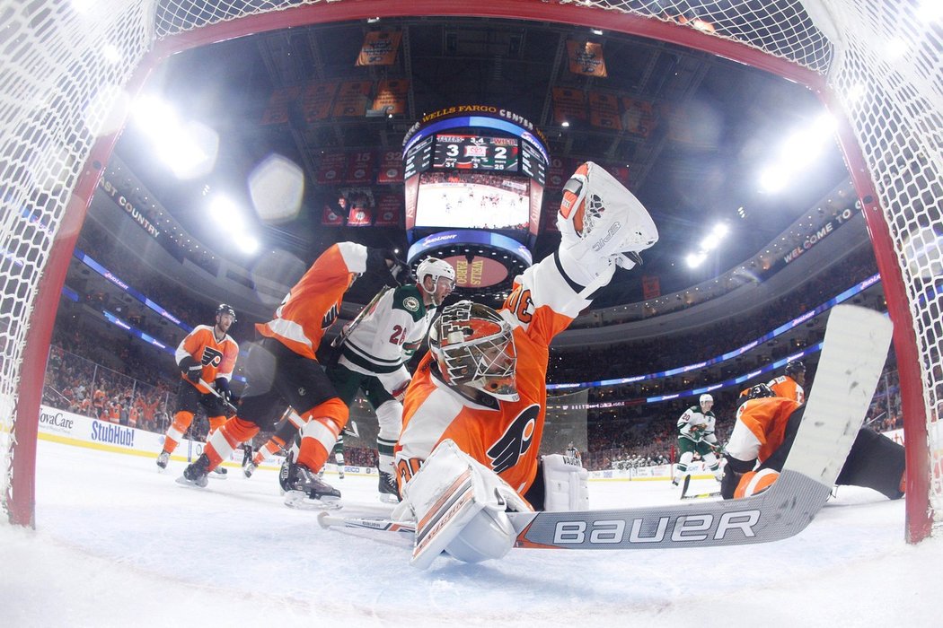 Michal Neuvirth v brance Philadelphie skáče po střele Charlieho Coylea z Minnesoty