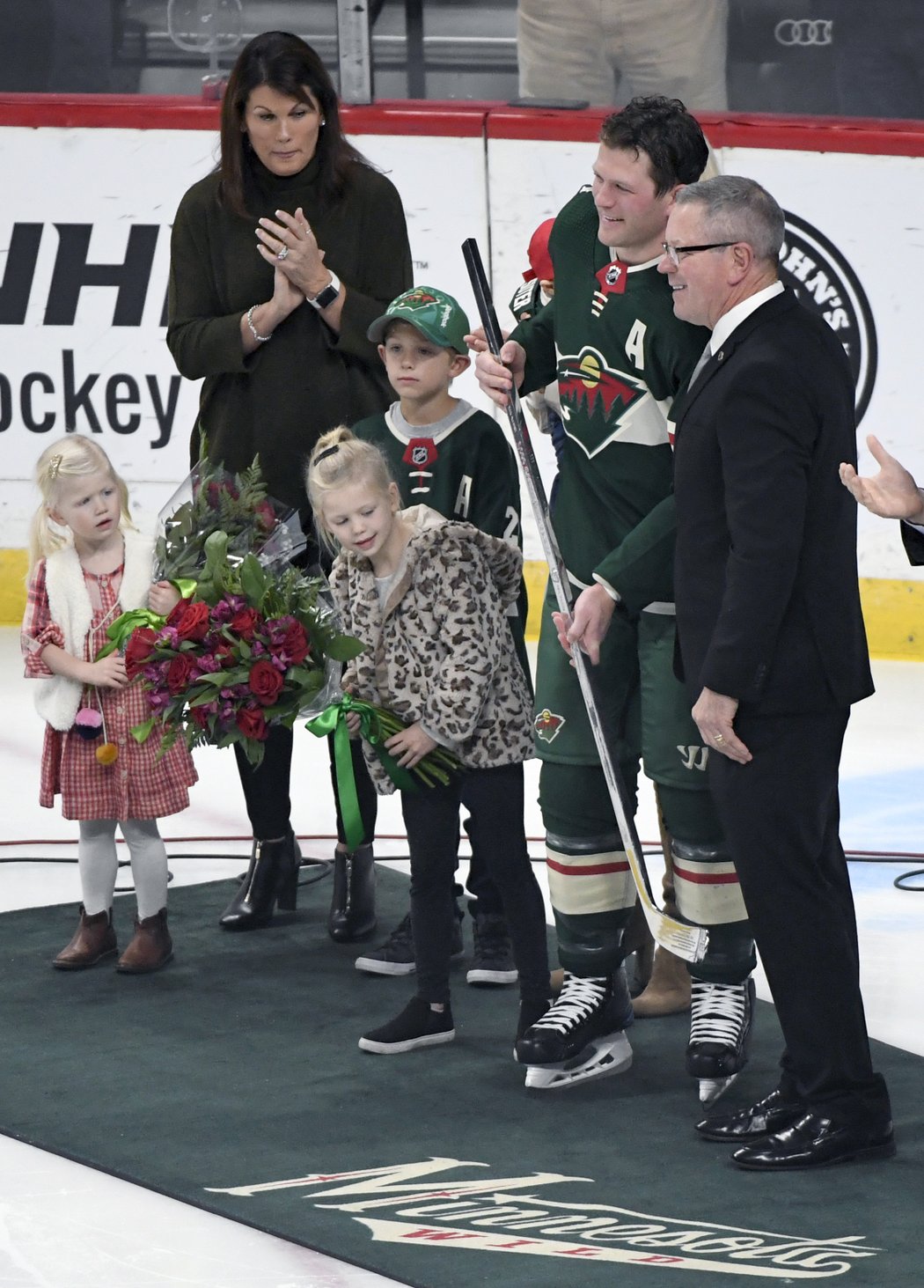 Majitel Minnesoty Paul Fenton předává obránci Ryanu Suterovi stříbrnou hokejku za tisíc odehraných utkání v NHL