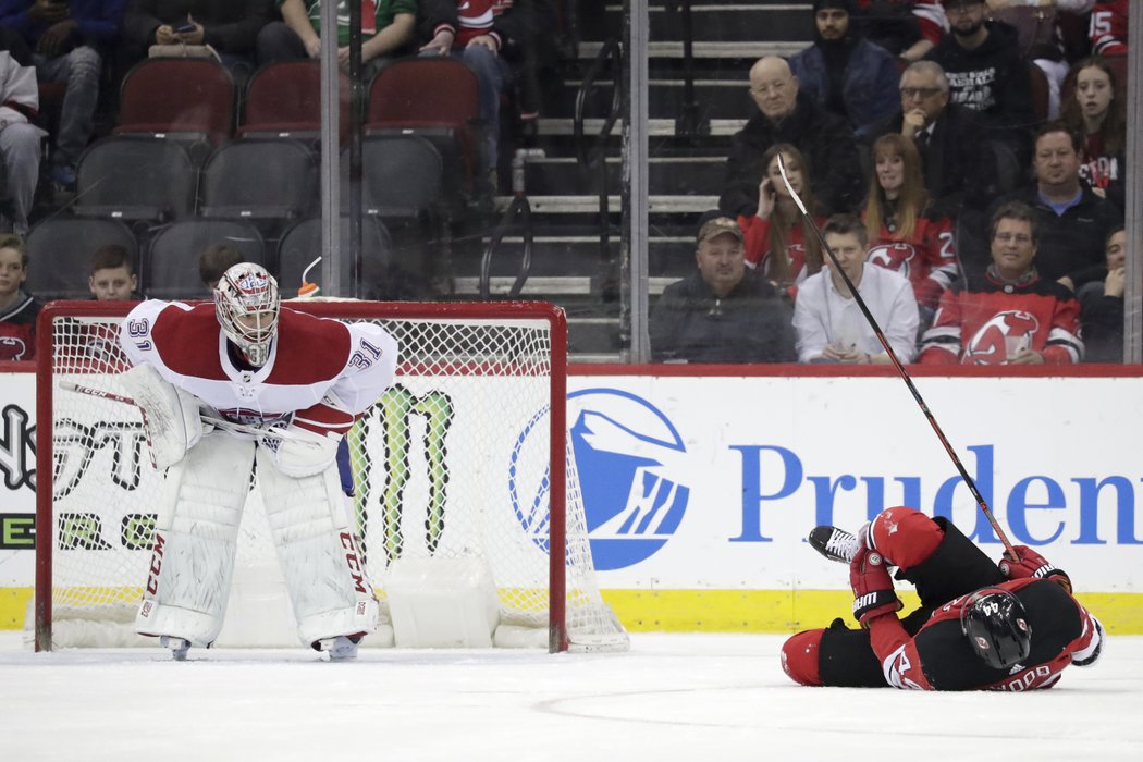 Carey Price pozoruje Milese Wooda z New Jersey, který právě schytal ránu pukem od jednoho ze spoluhráčů