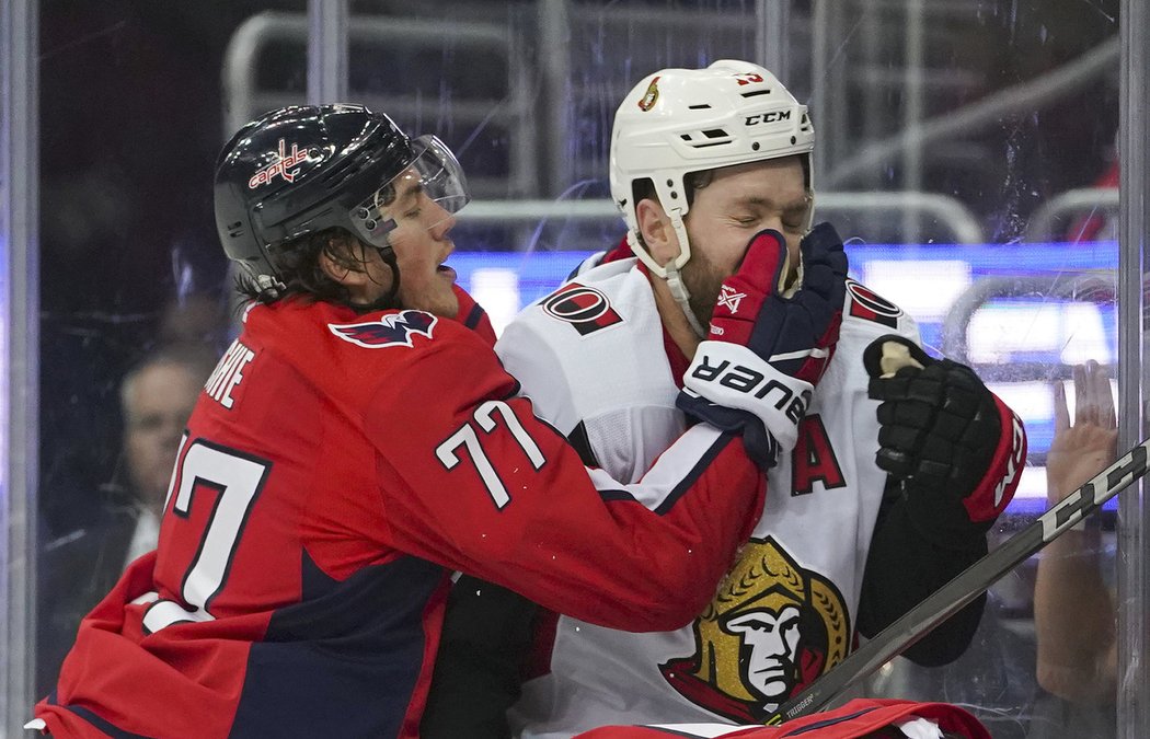 T.J. Oshie a Zack Smith během souboje u mantinelu