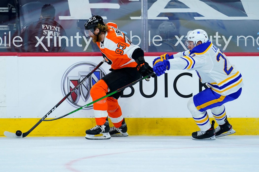 Jakub Voráček si kryje puk před Cody Eakinem v souboji s Buffalem