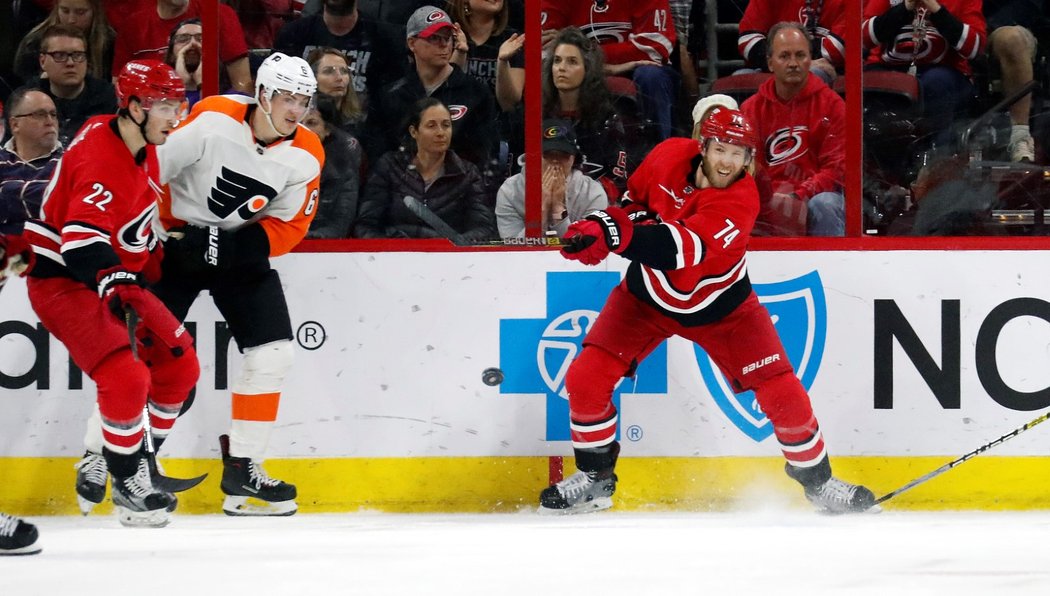 Brett Pesce (vlevo) a Travis Sanheim (uprostřed) svedli souboj o kotouč během zápasu Flyers - Canes