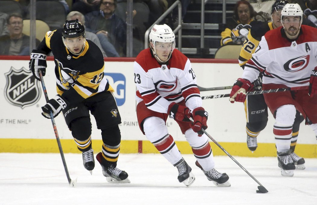 Brock McGinn přemýšlí o rozehrávce, Dominik Simon z Pittsburghu ho sleduje