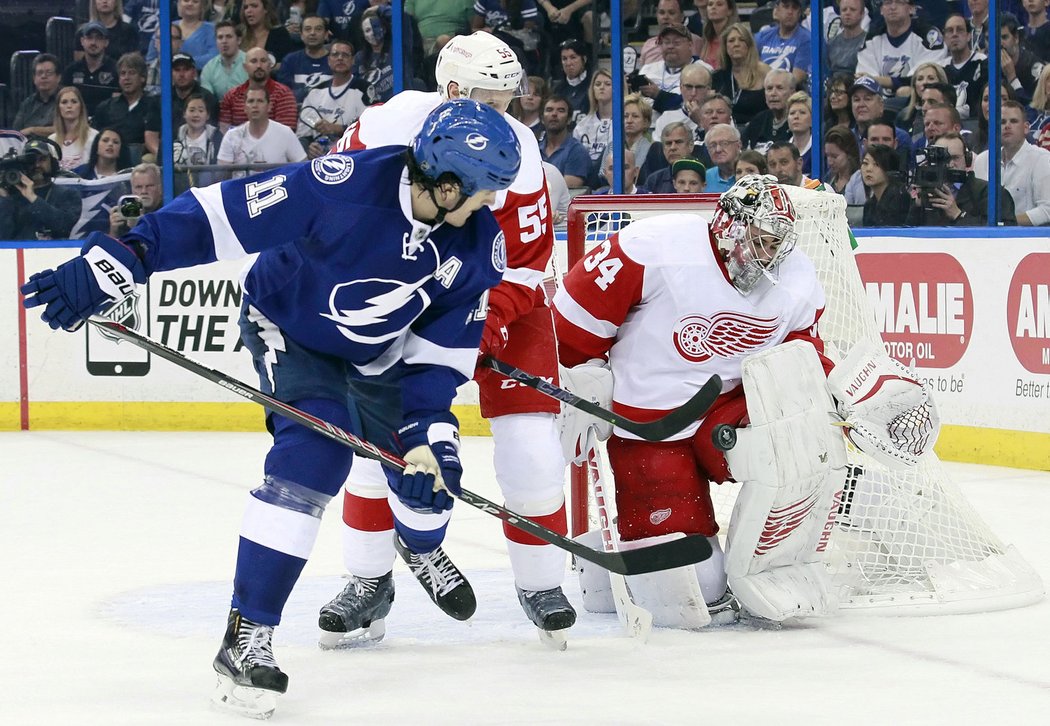 Brankář Detroitu Petr Mrázek zasahuje proti Brianu Boyleovi z Tampy v prvním zápase play off NHL