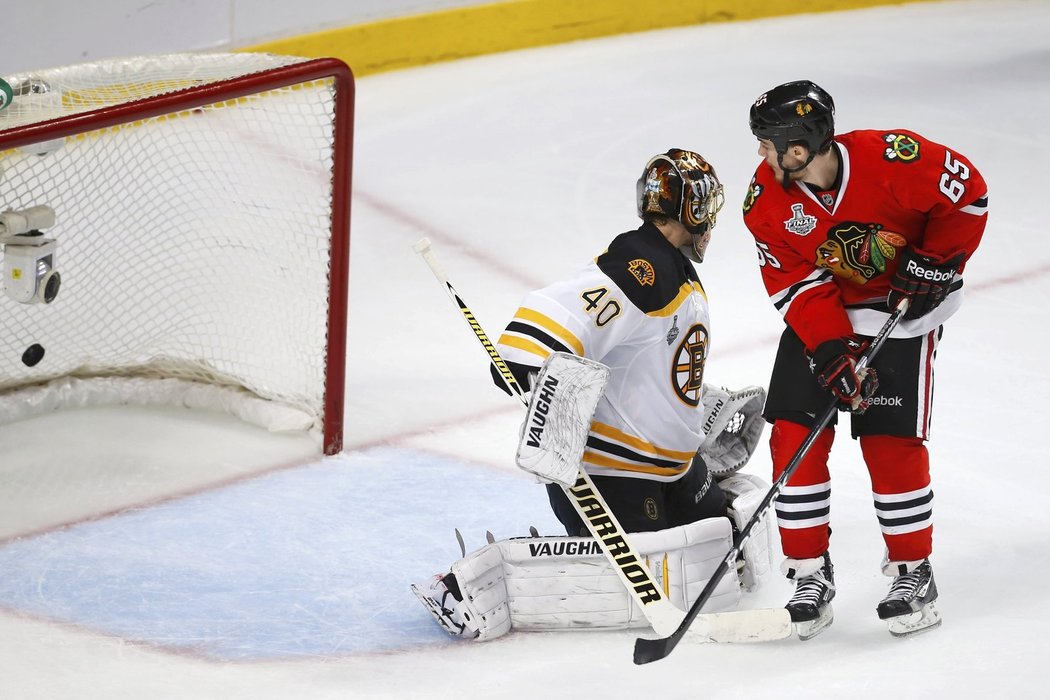 Andrew Shaw tečuje střelu Michala Rozsívala za záda bostonského Tuukky Raska ve třetím prodloužení prvního finále mezi Bruins a Chicagem
