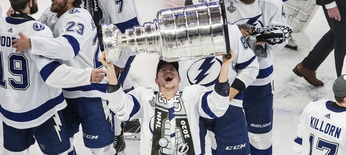 Ondřej Palát v klubku slavících parťáků z Tampy zvedá nad hlavu Stanley Cup