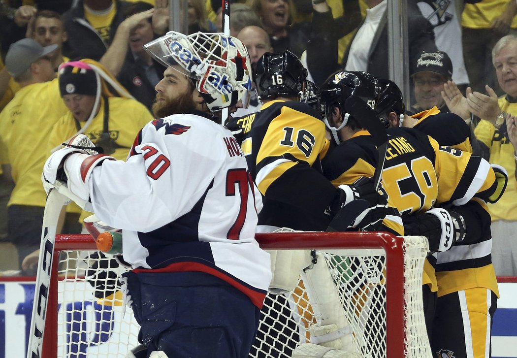 Zklamaný brankář Washingtonu Braden Holtby přihlíží radosti Pittsburghu po gólu Toma Kuhnhackla