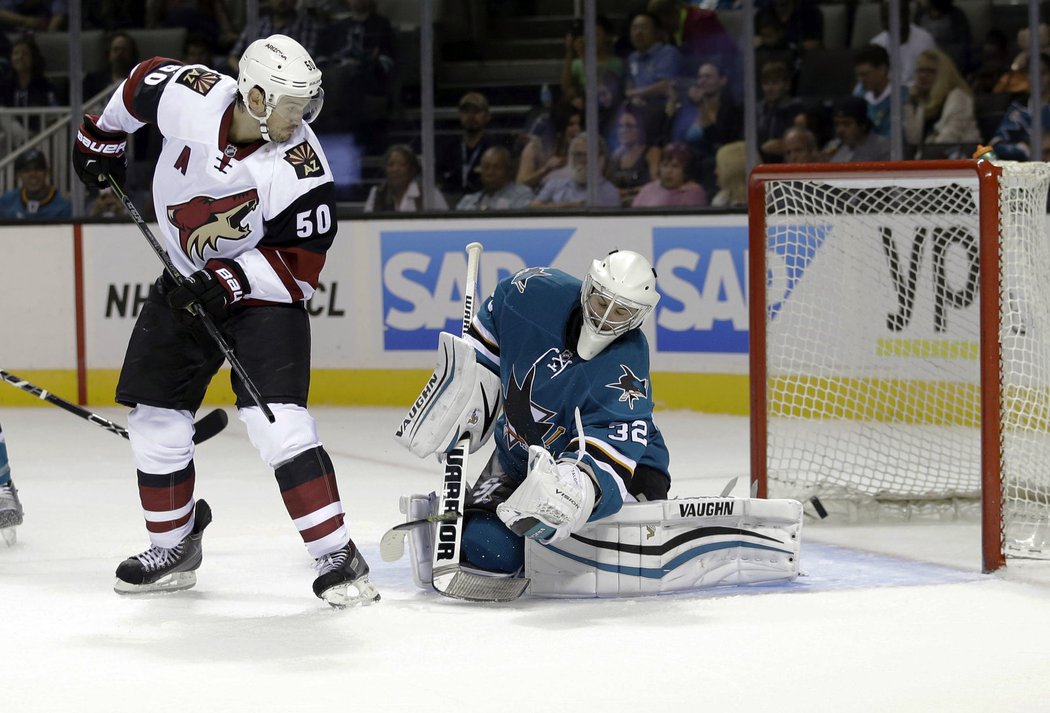 Antoine Vermette cloní před brankářem San Jose Alexem Stalockem