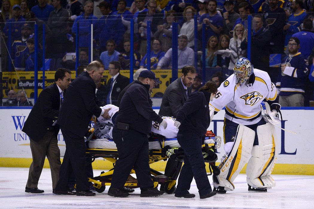 Brankář Pekka Rinne sleduje, jak je jeho spoluhráč Kevin Fiala odnášen na nosítkách