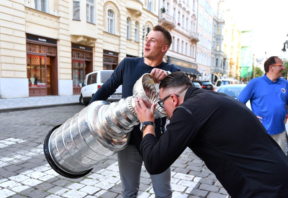 Jakub Vrána dává napít ze Stanley Cupu jednomu ze svých kamarádů