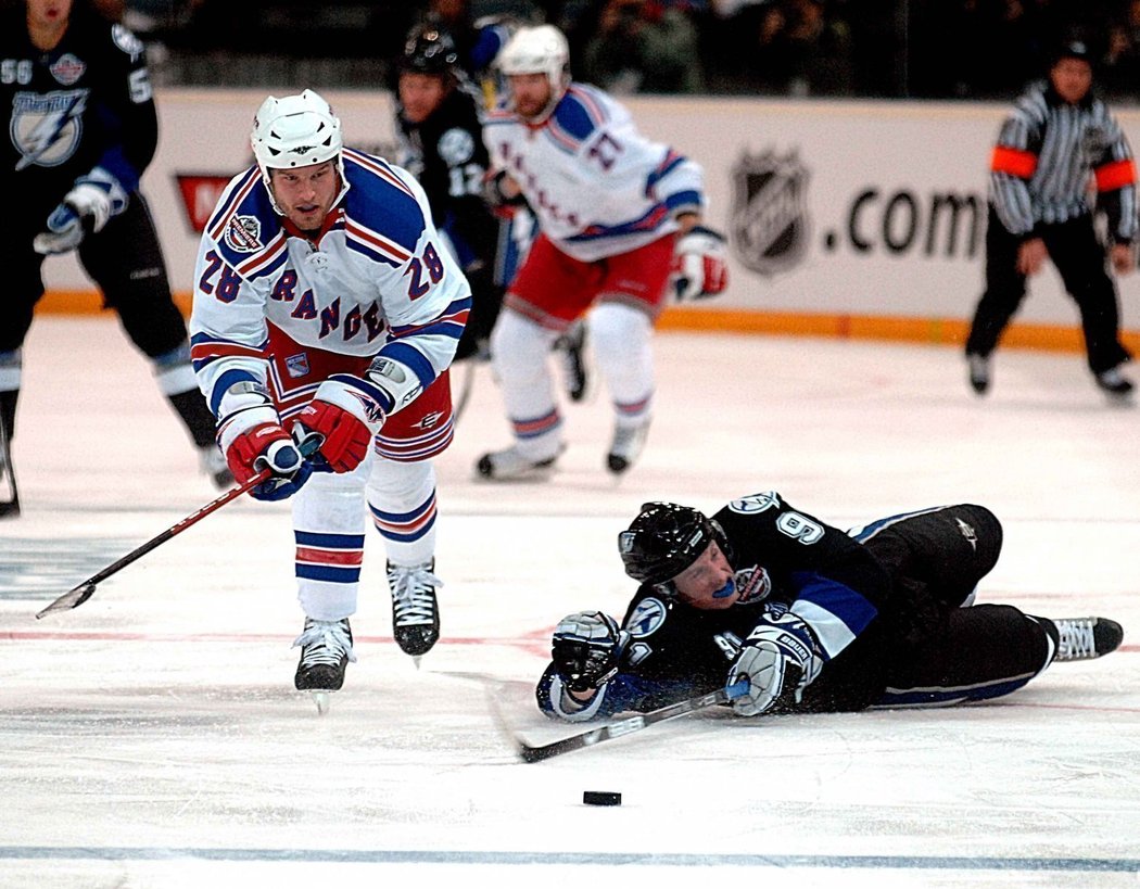 Ležící mladk Steven Stamkos se snaží zastavit bitkaře Rangers Orra