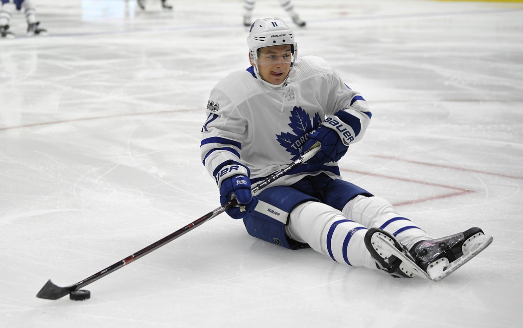 Torontský Zach Hyman se snaží rozehrát i vsedě po pádu na led v zápase s Los Angeles