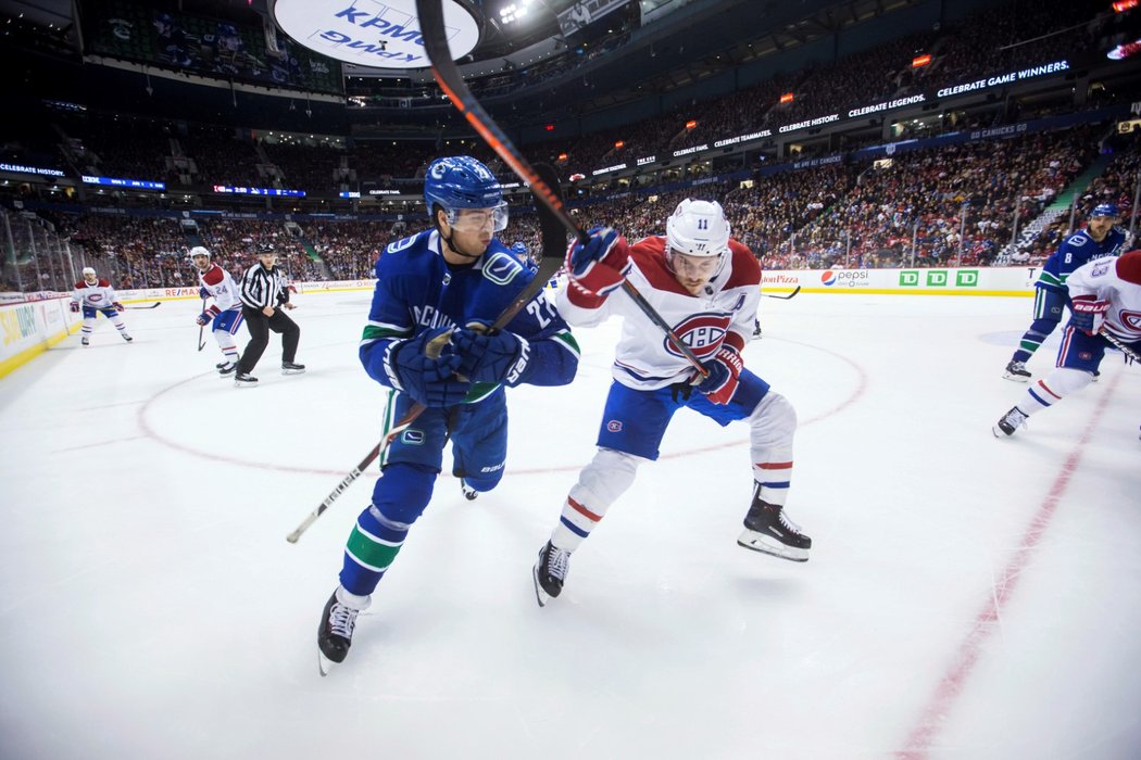 Zajímavá momentka z utkání Vancouver - Montreal: Ben Hutton bojuje v rohu o puk s Brendanem Gallagherem