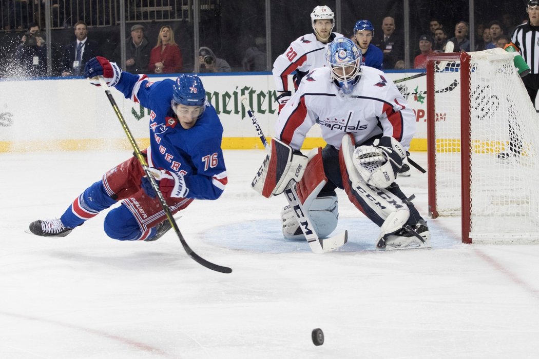 Obránce Brady Skjei z New York Rangers padá před brankou Washingtonu, kterou hájí Pheonix Copley